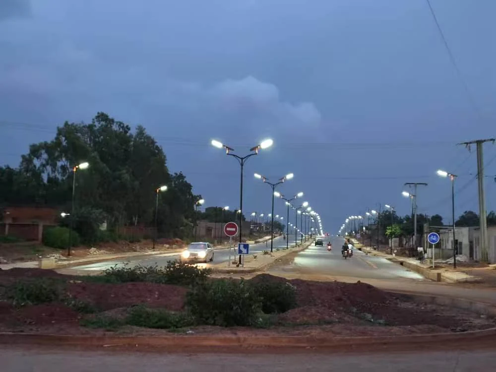 Luminarias solares todo en uno en un bulevar de Burkina Faso encendiéndose al anochecer