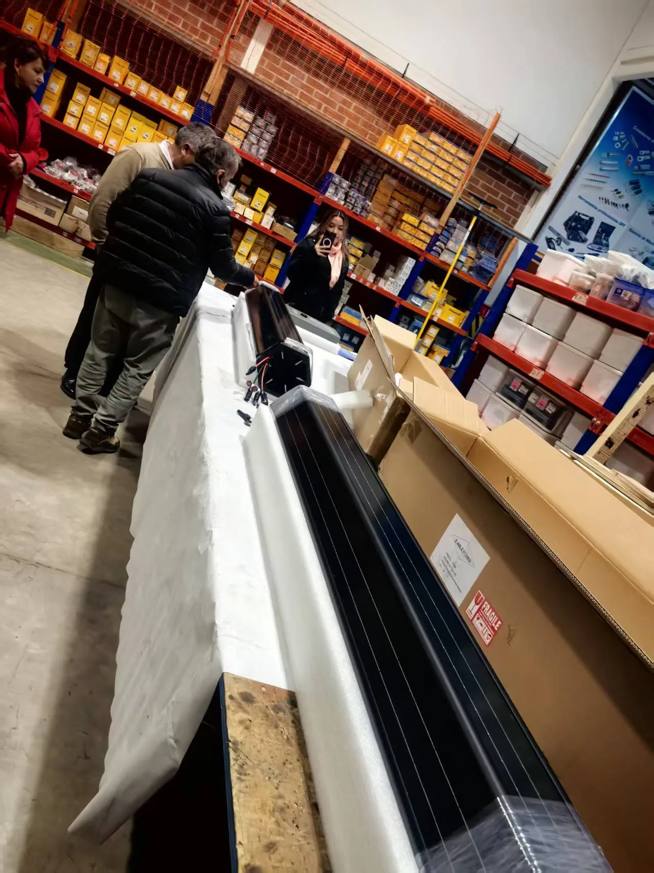 Unpacking SolarWrap cylindrical vertical solar modules from their export packaging in the Chile warehouse