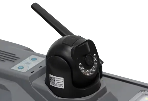 A black, dome-shaped CCTV camera with antennas and LED lights is mounted on the gray casing of a solar street light equipped with control bu